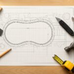 Blueprint of a swimming pool design with tools such as a hammer, ruler, and pencil.